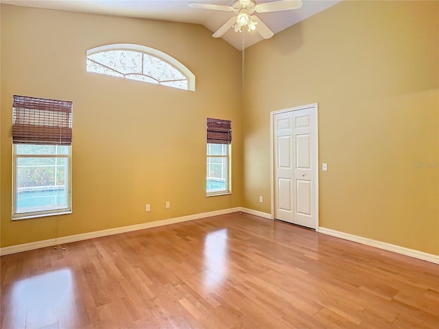 unfurnished room featuring lofted ceiling, light wood-type flooring, ceiling fan, and a wealth of natural light