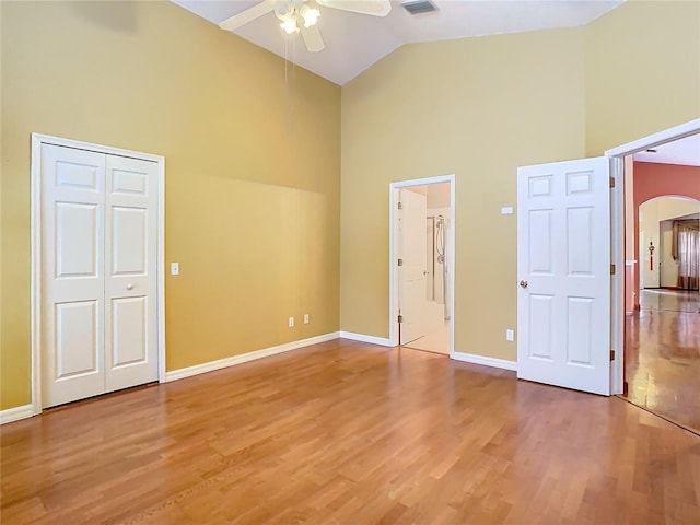 unfurnished bedroom featuring ceiling fan, high vaulted ceiling, and hardwood / wood-style flooring