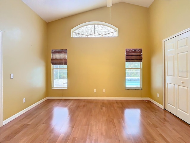 unfurnished room featuring high vaulted ceiling, light hardwood / wood-style flooring, and plenty of natural light