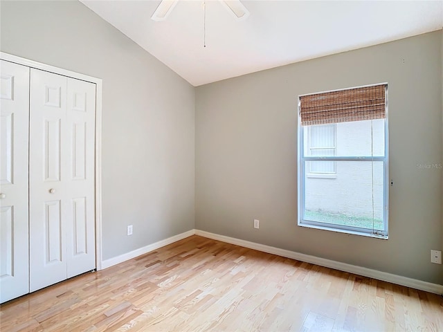 unfurnished bedroom featuring lofted ceiling, ceiling fan, a closet, and light hardwood / wood-style flooring