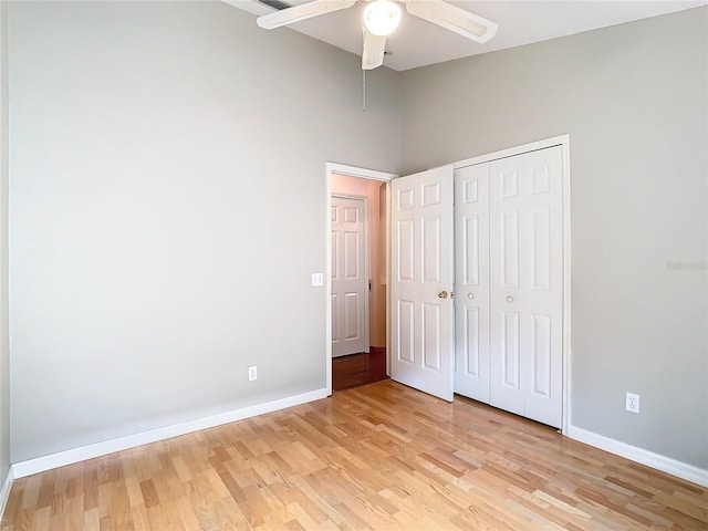 unfurnished bedroom with ceiling fan, light hardwood / wood-style flooring, and a closet