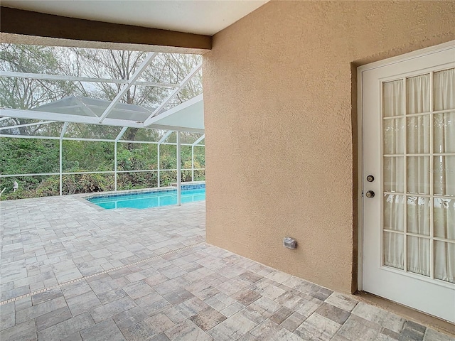 view of swimming pool featuring a lanai and a patio