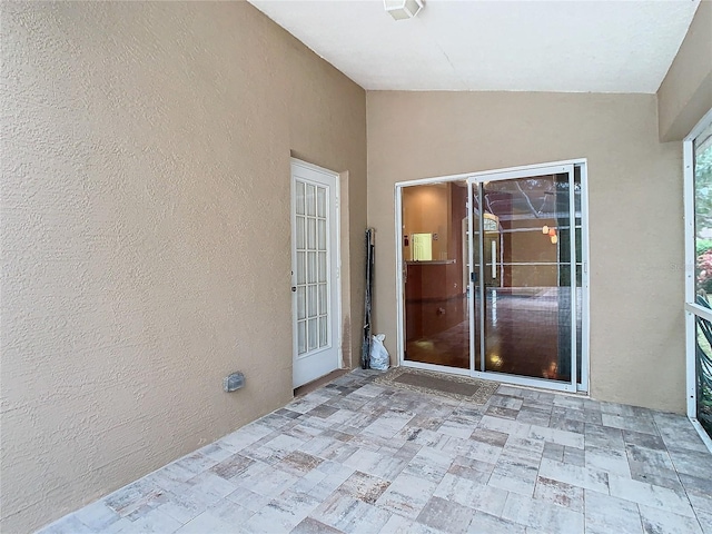 unfurnished sunroom featuring vaulted ceiling