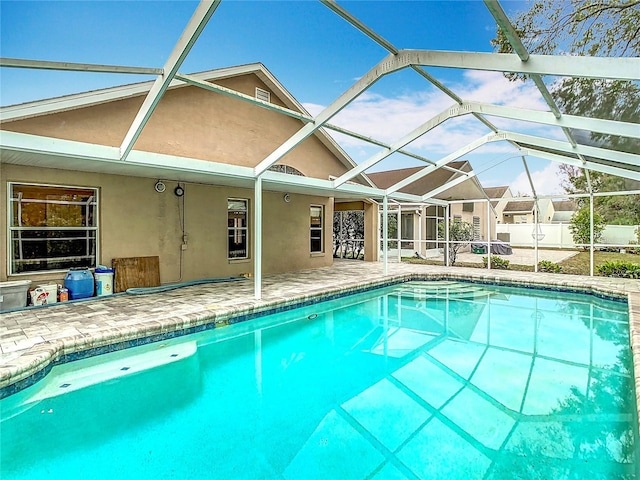 view of pool with a patio area and glass enclosure