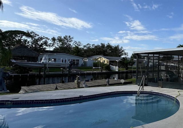 view of swimming pool with a dock and a water view