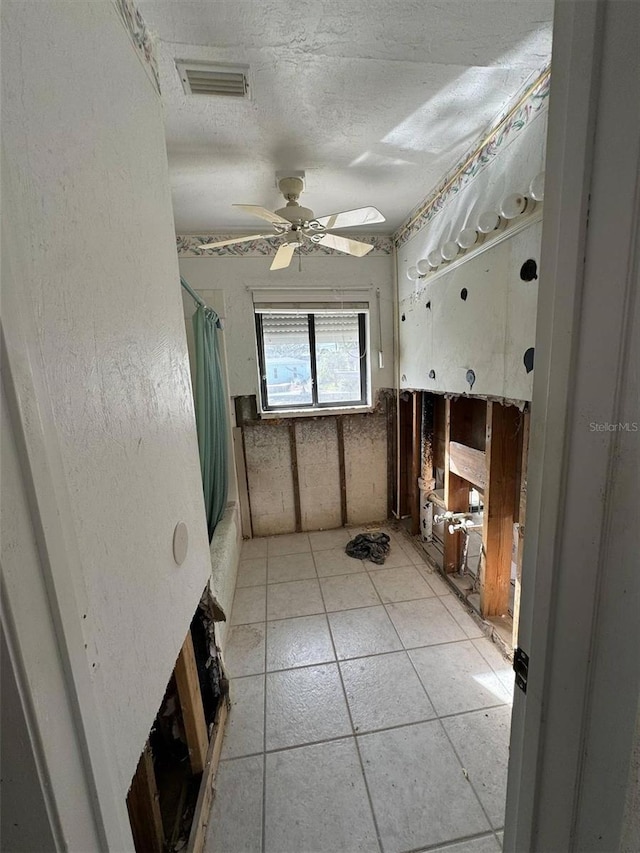 bathroom featuring a textured ceiling, ceiling fan, and shower / bath combo with shower curtain