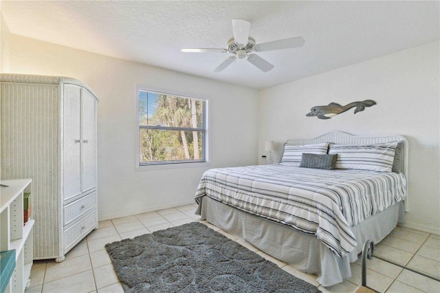 tiled bedroom with ceiling fan and a textured ceiling