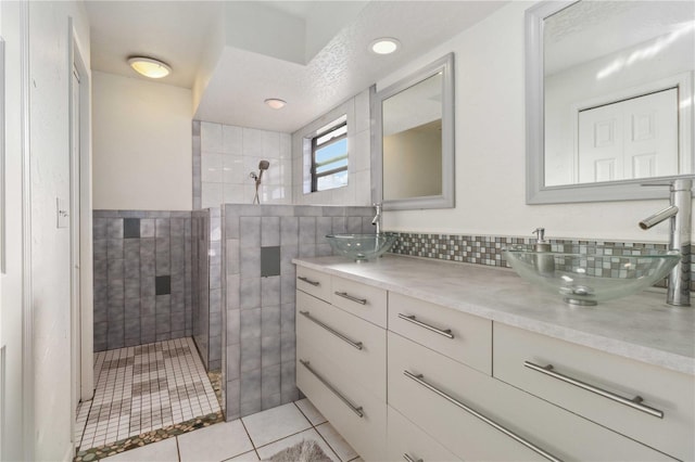 bathroom featuring tile patterned floors, vanity, and a tile shower