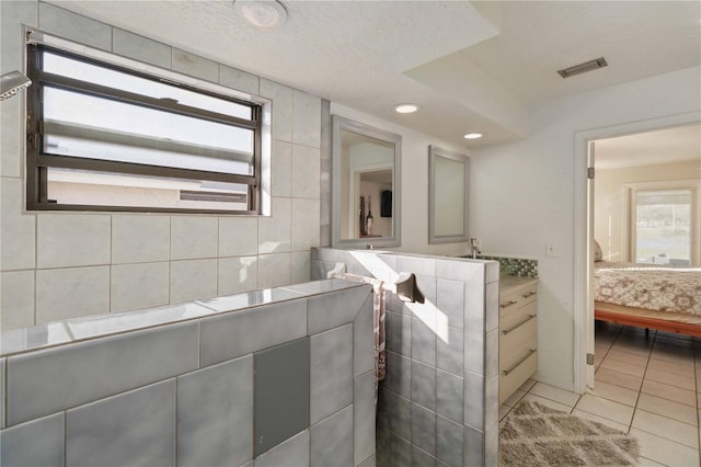 bathroom with tile patterned floors, a textured ceiling, and tile walls