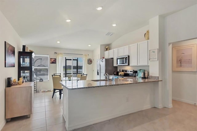 kitchen featuring kitchen peninsula, white cabinetry, stone counters, appliances with stainless steel finishes, and sink