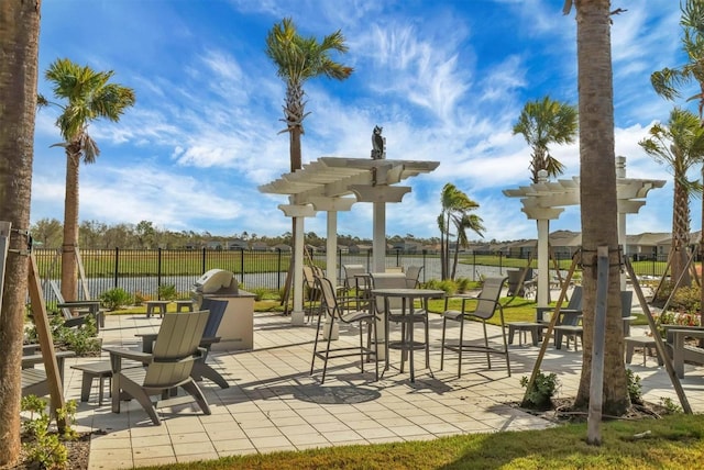 view of community with a patio, a pergola, and a water view