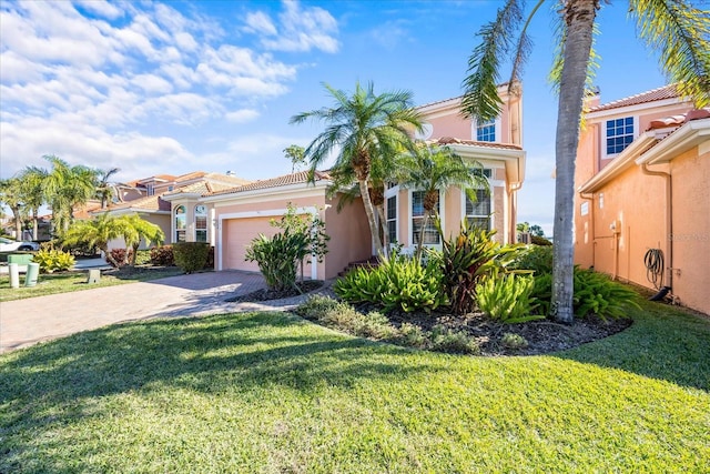 mediterranean / spanish house with a garage and a front yard