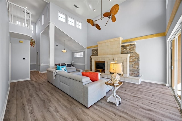 living room featuring a towering ceiling, hardwood / wood-style floors, and ceiling fan