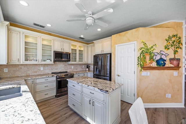 kitchen featuring stainless steel appliances, a center island, sink, and backsplash