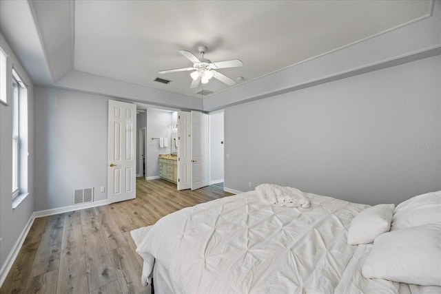 bedroom featuring light hardwood / wood-style flooring, ceiling fan, and ensuite bathroom