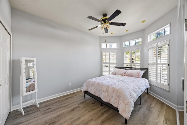 bedroom with ceiling fan, hardwood / wood-style floors, and a closet