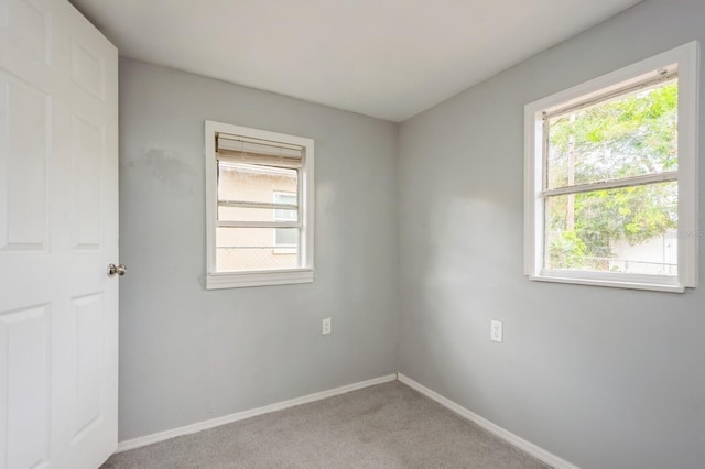 spare room featuring light colored carpet