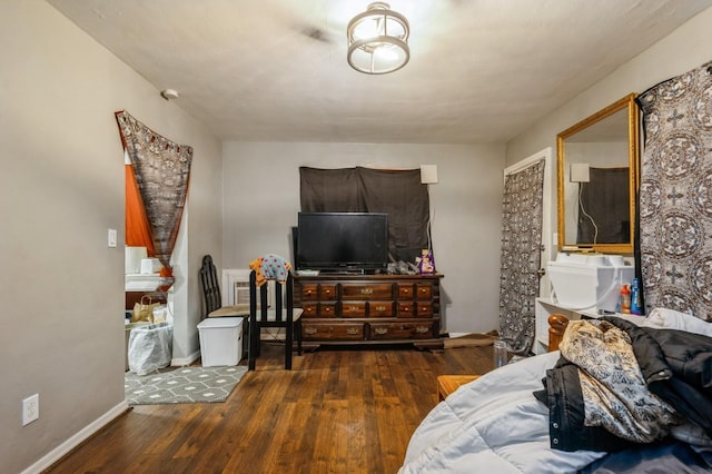 bedroom featuring dark wood-type flooring and a wall unit AC