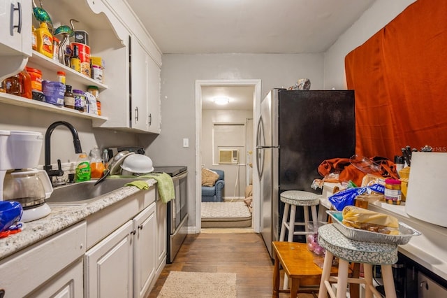 kitchen featuring white cabinets, stainless steel appliances, light hardwood / wood-style floors, and sink