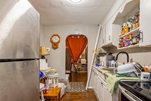 kitchen with appliances with stainless steel finishes, white cabinetry, dark hardwood / wood-style floors, and sink