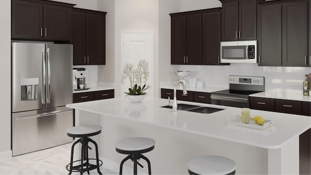 kitchen featuring sink, stainless steel appliances, a breakfast bar, and a center island with sink