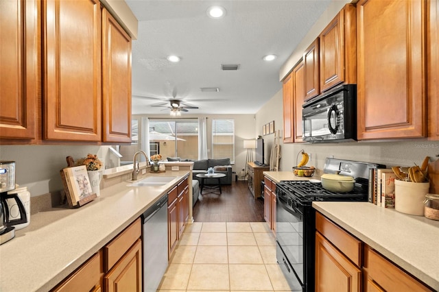 kitchen featuring sink, light tile patterned floors, ceiling fan, and black appliances