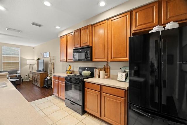 kitchen with light tile patterned floors and black appliances