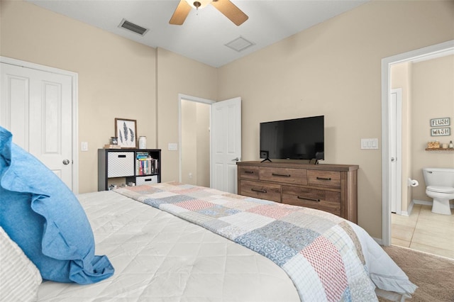 bedroom with ceiling fan, ensuite bathroom, and carpet flooring