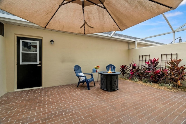 view of patio / terrace featuring an outdoor fire pit and a lanai