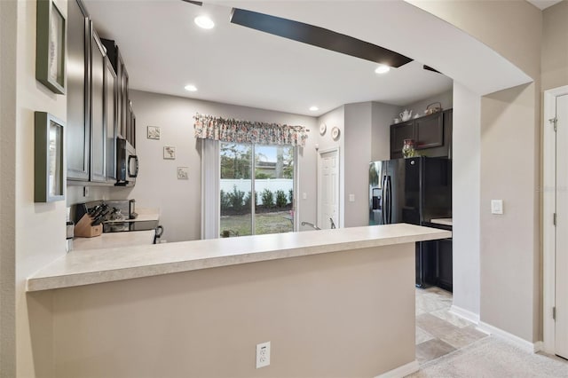 kitchen featuring kitchen peninsula, black refrigerator with ice dispenser, and stove