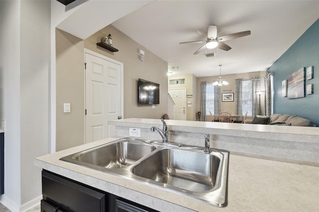 kitchen with sink, ceiling fan with notable chandelier, and hanging light fixtures