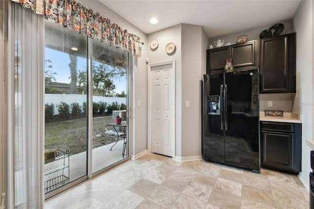 kitchen with black refrigerator with ice dispenser