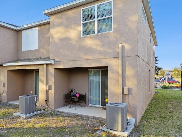 rear view of house featuring a yard, central AC unit, and a patio