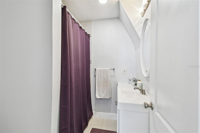 bathroom with curtained shower, a textured ceiling, and vanity