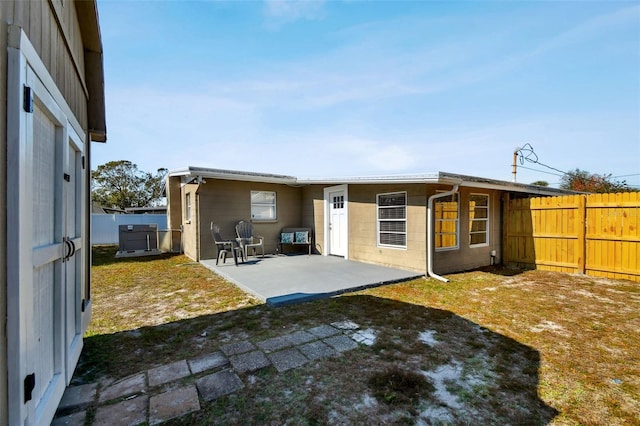 back of property with a yard and a patio