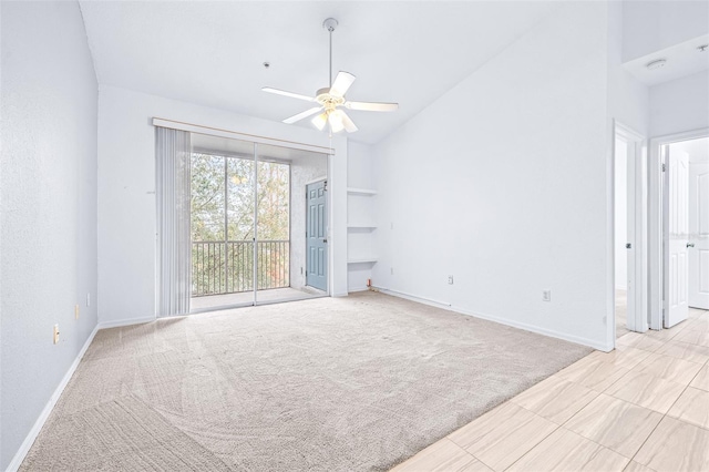 carpeted empty room with ceiling fan and lofted ceiling