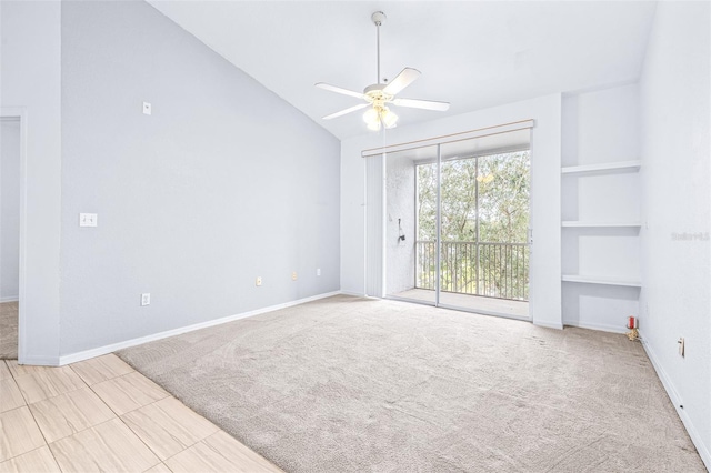 spare room with light carpet, ceiling fan, lofted ceiling, and built in shelves