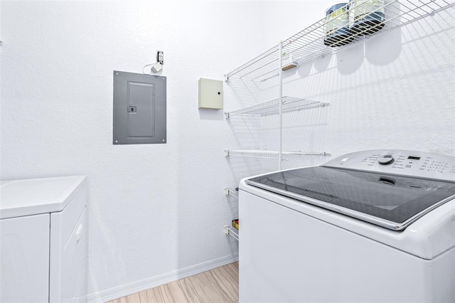 washroom featuring light hardwood / wood-style floors, electric panel, and washer / dryer