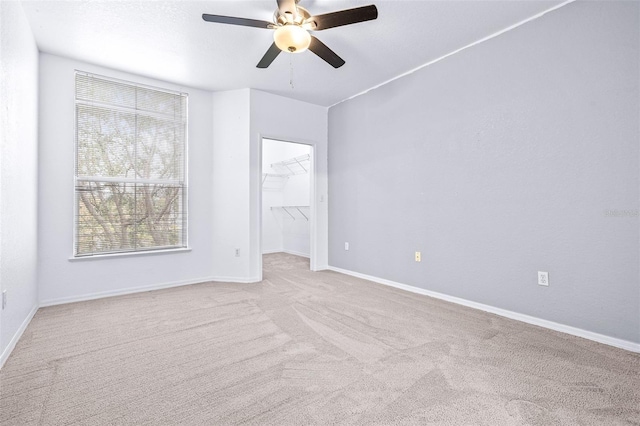 carpeted spare room with ceiling fan