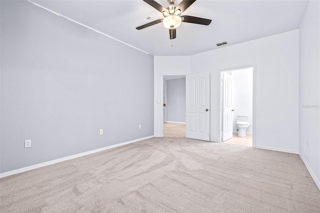 unfurnished bedroom with ceiling fan, light colored carpet, and ensuite bath