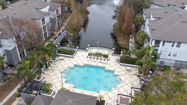 view of pool with a water view and a patio