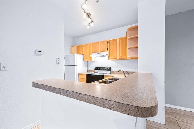 kitchen featuring kitchen peninsula, a kitchen bar, sink, range with electric cooktop, and white refrigerator