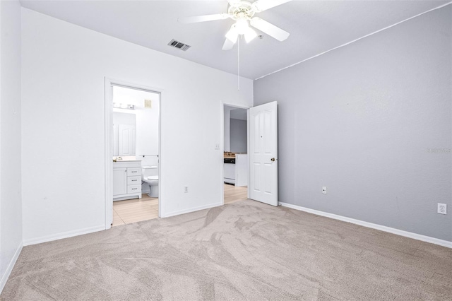 unfurnished bedroom featuring ceiling fan, light carpet, and connected bathroom