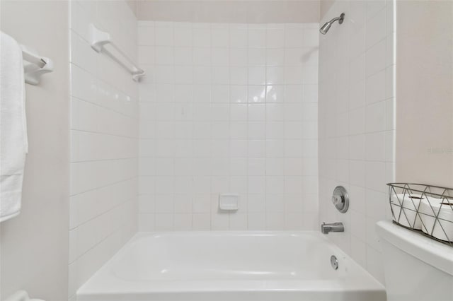 bathroom featuring tiled shower / bath and toilet