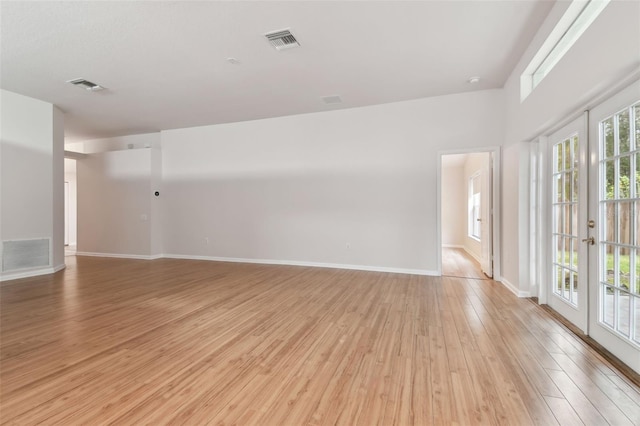 spare room with light hardwood / wood-style floors and french doors