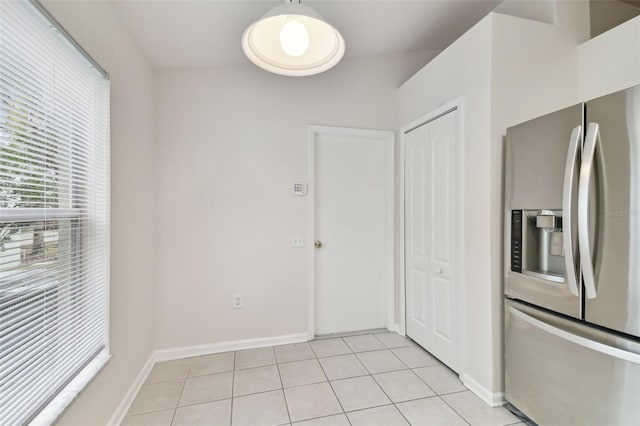 kitchen with light tile patterned flooring and stainless steel fridge