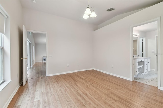 spare room featuring sink, an inviting chandelier, and light wood-type flooring