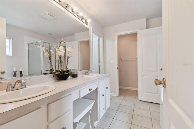 bathroom with vanity, a shower with shower door, and tile patterned floors