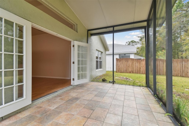 unfurnished sunroom featuring vaulted ceiling