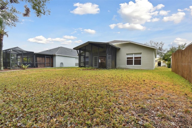 back of property featuring a sunroom and a lawn